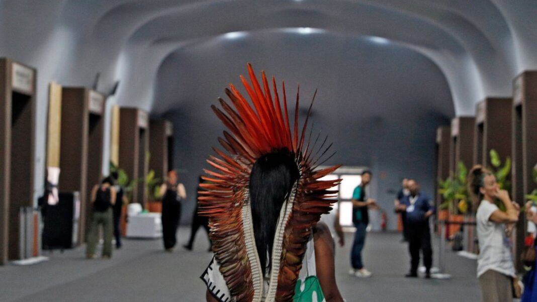 Mulher indígena caminha nas dependências da COP30