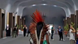 Mulher indígena caminha nas dependências da COP30