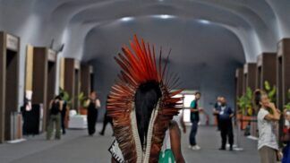 Mulher indígena caminha nas dependências da COP30