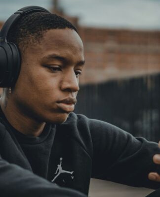 Homem ouvindo música no fone de ouvido e olhando o celular