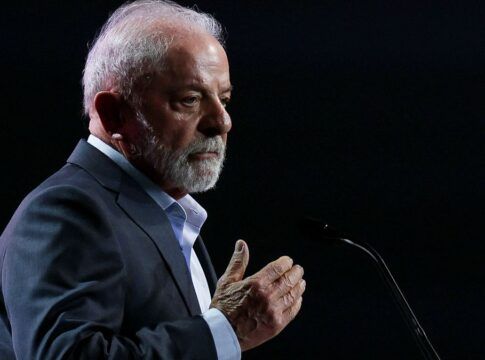 Lula faz gesto com a mão direita enquanto faz declaração ao microfone