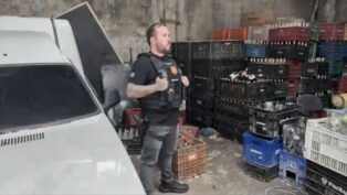 Policial participa de mandado de busca em depósito cheio de garrafas vazias