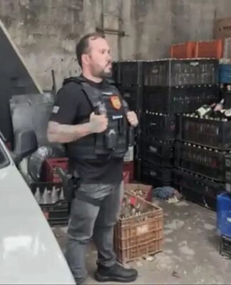Policial participa de mandado de busca em depósito cheio de garrafas vazias