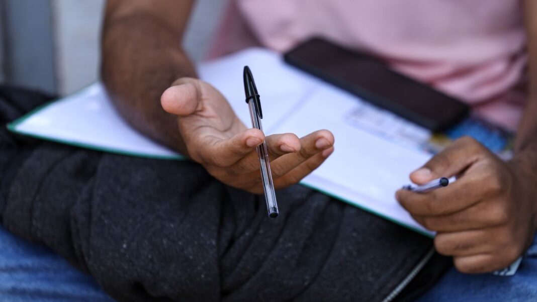 Candidato segura caneta e checa informações da prova depois do segundo dia do Enem no último domingo