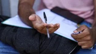 Candidato segura caneta e checa informações da prova depois do segundo dia do Enem no último domingo