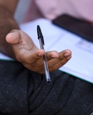 Candidato segura caneta e checa informações da prova depois do segundo dia do Enem no último domingo