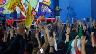 Multidão de sindicalizados em greve levantando as mãos