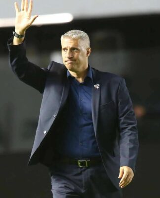 Crespo de terno escuro, acenando para torcida, do campo.