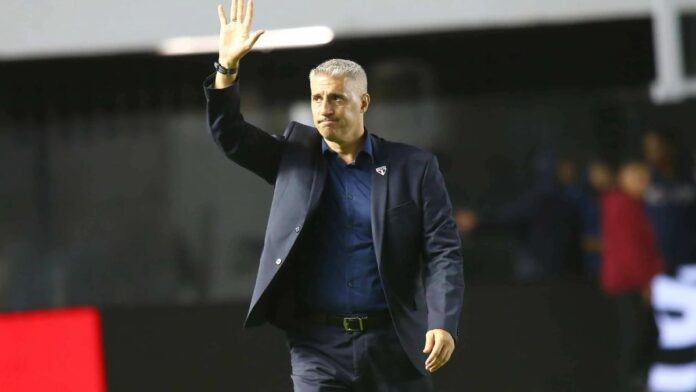 Crespo de terno escuro, acenando para torcida, do campo.