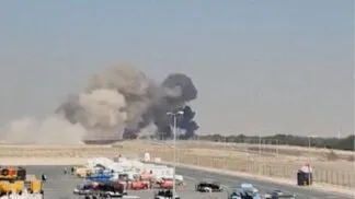 Foto à distância da fumaça preta subindo após a queda do caça