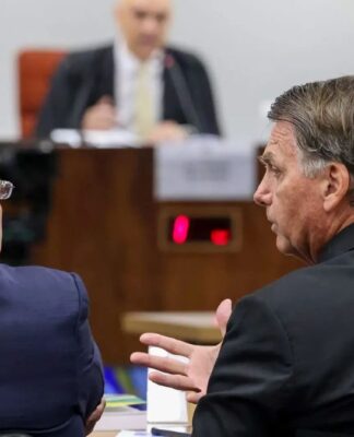 Jair Bolsonaro fala com advogado durante audiência em seu julgamento, com o ministro Alexandre de Moraes ao fundo