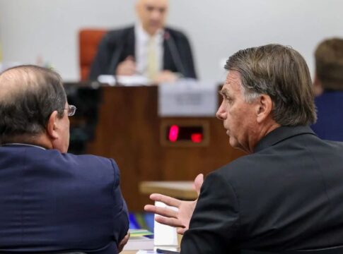 Jair Bolsonaro fala com advogado durante audiência em seu julgamento, com o ministro Alexandre de Moraes ao fundo