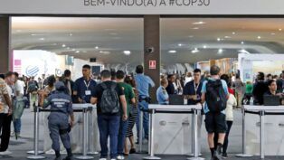 Multidão atravessando os portões de entrada da COP30