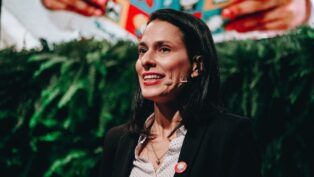 Simone Mozzilli com microfone, em evento