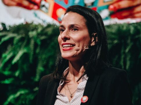 Simone Mozzilli com microfone, em evento