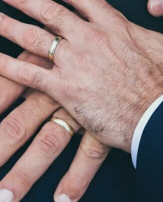 Duas mãos masculinas com alianças