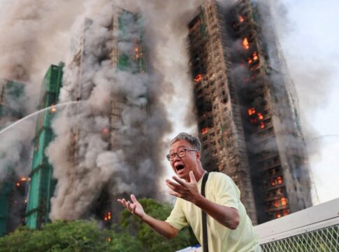 Homens do Corpo de Bombeiros trabalham para conter o fogo em três prédios em Hong Kong