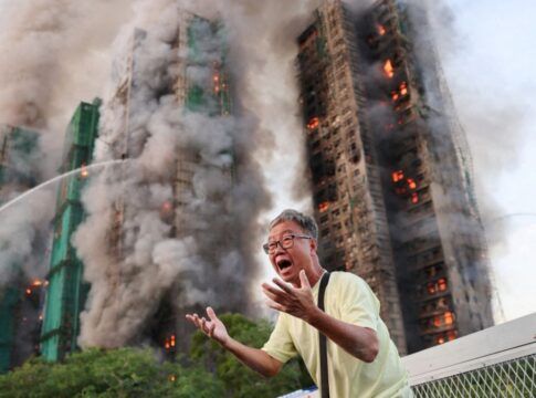 Homens do Corpo de Bombeiros trabalham para conter o fogo em três prédios em Hong Kong
