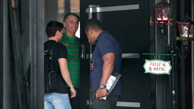 Jair Bolsonaro veste camisa verde na entrada de sua casa