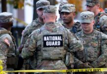 Soldados da Guarda Nacional reunidos atrás de uma linha policial