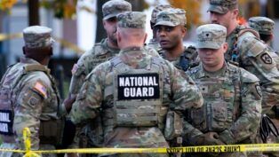 Soldados da Guarda Nacional reunidos atrás de uma linha policial