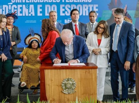 Lula assinando projeto de lei em palanque com ministros em volta