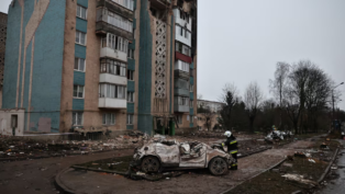 Um bombeiro observa um carro destruído durante um ataque mortal de mísseis russos a um prédio de apartamentos, em meio ao ataque da Rússia à Ucrânia, em Ternopil, Ucrânia, 21 de novembro de 2025.