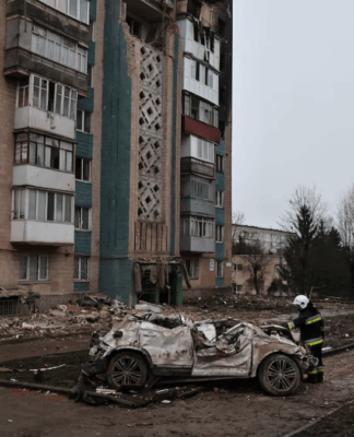 Um bombeiro observa um carro destruído durante um ataque mortal de mísseis russos a um prédio de apartamentos, em meio ao ataque da Rússia à Ucrânia, em Ternopil, Ucrânia, 21 de novembro de 2025.