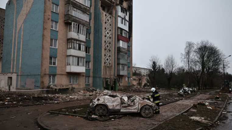 Um bombeiro observa um carro destruído durante um ataque mortal de mísseis russos a um prédio de apartamentos, em meio ao ataque da Rússia à Ucrânia, em Ternopil, Ucrânia, 21 de novembro de 2025.