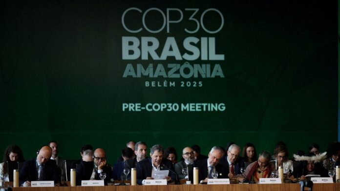 Políticos sentados em evento de abertura na COP30. Ao fundo, uma parede verde com os dizeres COP 30-BRASIL-AMAZÔNIA-PRE-COP30 MEETING