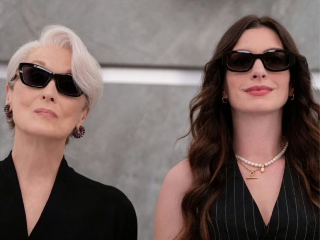 Anne Hathaway e Meryl Streep vestidas de preto no elevador.