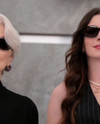 Anne Hathaway e Meryl Streep vestidas de preto no elevador.