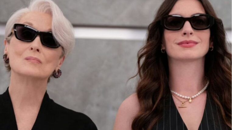 Anne Hathaway e Meryl Streep vestidas de preto no elevador.
