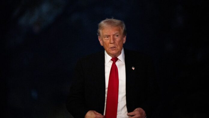 O presidente dos Estados Unidos, Donald Trump, vestindo um terno com um fundo escuro.