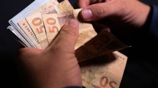 Notas de cinquenta reais sendo contadas.