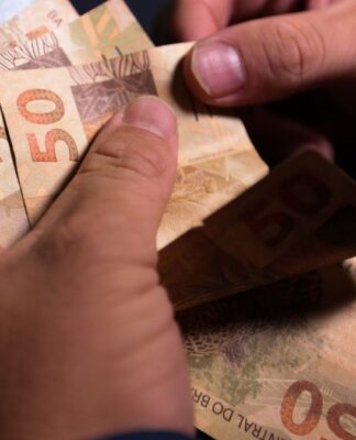 Notas de cinquenta reais sendo contadas.