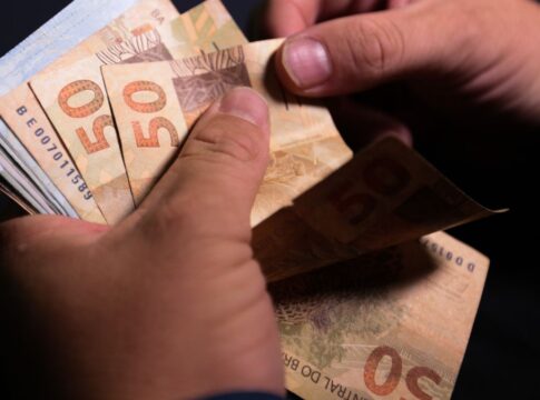 Notas de cinquenta reais sendo contadas.