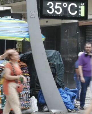 Imagem mostra um termômetro de rua mostrando a temperatura em 35º C com pessoas caminhando ao redor