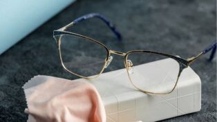 Óculos em cima de uma mesa com pano microfibra.