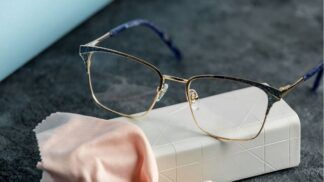 Óculos em cima de uma mesa com pano microfibra.