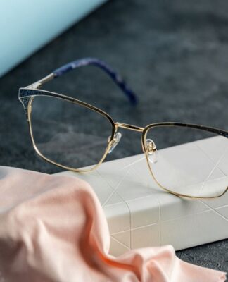 Óculos em cima de uma mesa com pano microfibra.