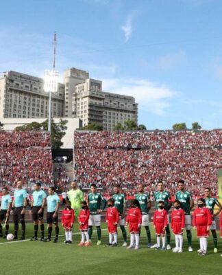 Os times de Palmeiras e Flamengo estão perfilados, com seus uniformes, para o hino nacional no gramado