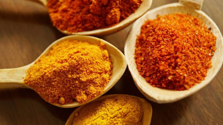 na imagem, colheres contendo cúrcuma em pó