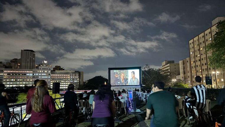 Pessoas pedalando bicicletas enquanto assistem um filme em um telão