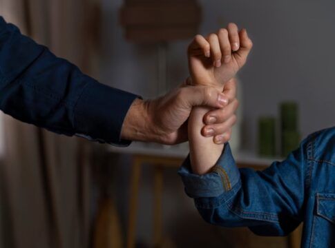 Mão segurando um braço com força