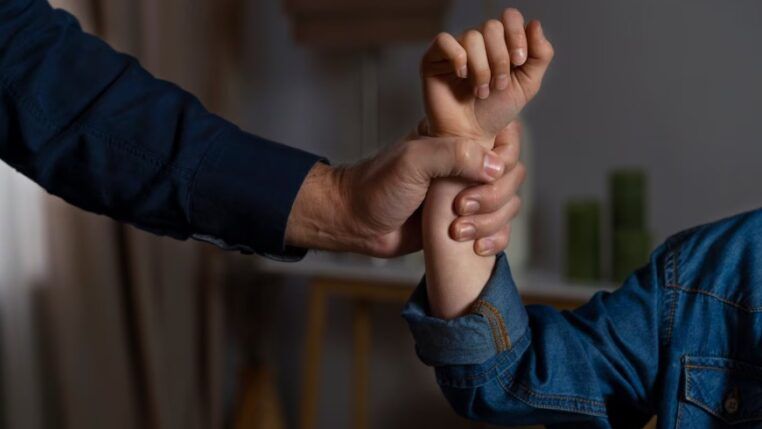 Mão segurando um braço com força