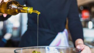 Em imagem ilustrativa, cozinheira(o) prepara alimento ultilizando azeite