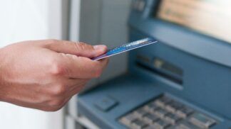 Em imagem ilustrativa, pessoa consulta sua conta em caixa eletrônico