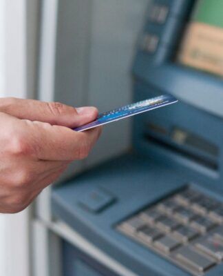 Em imagem ilustrativa, pessoa consulta sua conta em caixa eletrônico