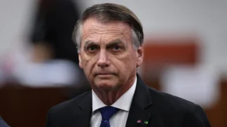 Imagem de Bolsonaro em primeiro plano durante o julgamento no STF.